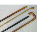 A collection of four assorted vintage walking sticks, one with brass top, one with ivory inlay,