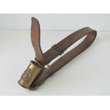 A Victorian brown leather belt having brass flag support upon.