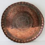 A large 19th century Middle Eastern circular copper tray having raised scalloped border with