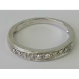 A 9ct white gold and diamond ring having nine round cut diamonds set in all white metal hallmarked