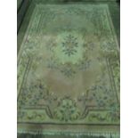 A woolen and silk pink ground Chinese style rug measuring 244 x 170cm.