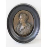 A bronze miniature portrait in relief of a lady in fur shawl, 8 x 6.5cm within ebonised frame.