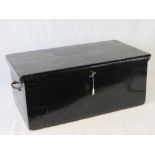 A black painted wooden travelling trunk having twin end handles and complete with key.