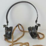 A pair of WWII field headphones stamped DLR1 4035A.