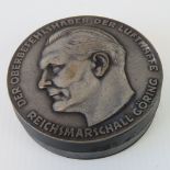 A snuff box with white metal top having embossed profile of Goering upon,