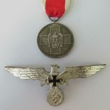 A WWII German Red Cross medal together with a WWII German Veterans Eagle badge. Two items.