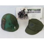 A US military Vietnam War period helmet, together with a USMC peaked cap, and a Vietnam War DVD set.