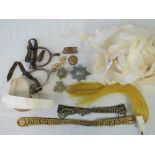 A collection of military attachments including helmet plumes, insignia, chin straps and spurs.