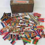 A cigar box containing a collection of medal ribbons and mounts.
