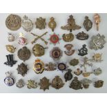 Forty military and civil badges including an enamelled Nottinghamshire Ambulance Service badge,