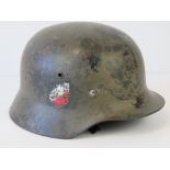 A WWII German army helmet having double decal and camouflage paint, bearing name upon,