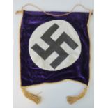 A WWII German purple velvet wall hanging having swastika upon with gilt braid and tassels.