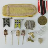 A WWII German buckle, a pair of Army Medic shoulder badges, two WWII German regiment flag badges,