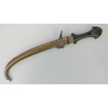 An Eastern dagger having curved steel blade, engraved brass guard and hard wood handle,