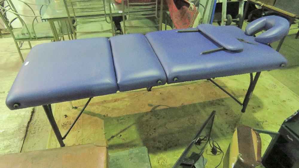 A purple leatherette massage table.