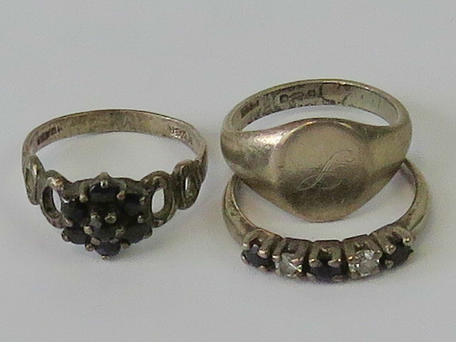 Three silver rings; a signet ring size H