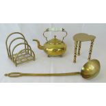 A brass kettle raised over ball feet wit