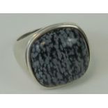 A silver ring having large grey and blac