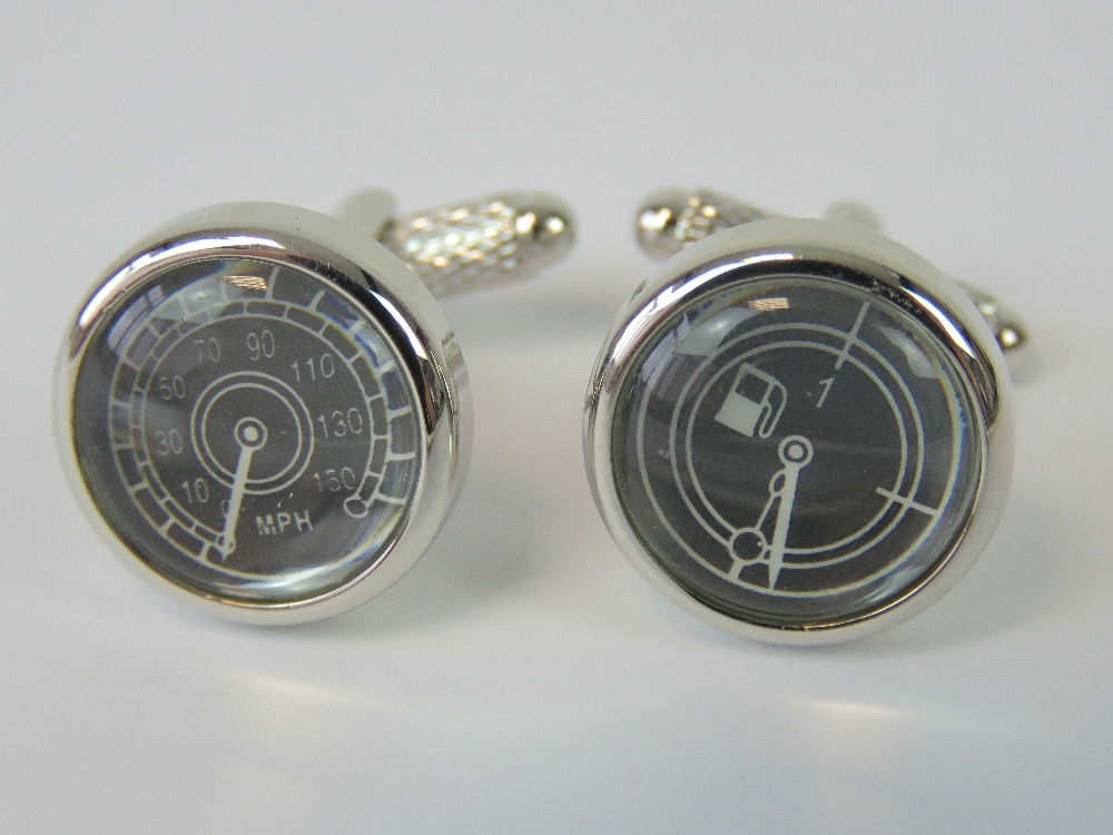 A pair of cufflinks in the form of a speedometer and fuel gauge.