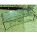 A 20th century glass top brass framed coffee table having reeded legs terminating in lions paw feet,