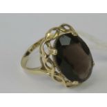 A 9ct gold smoky quartz ring having large oval cut quartz claw set in yellow metal hallmarked 375,