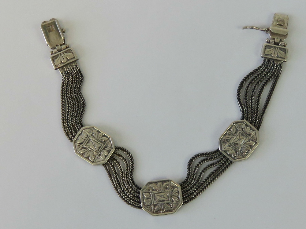 A silver five row woven chain bracelet having three octagonal panels upon, stamped 925, 18.