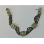 A silver five row woven chain bracelet having three octagonal panels upon, stamped 925, 18.