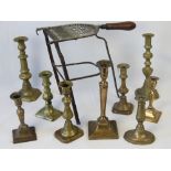 A quantity of assorted single brass candlesticks together with a brass and cast iron trivet,