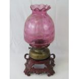 A red painted Victorian cast iron table lamp with scroll feet and two handles,