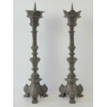 A fine pair of Victorian Gothic Revival bronzed brass pricket candlesticks each raised over triform