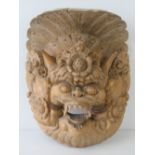 An Indo-Asian 20th century carved wall hanging mask, 23cm high.