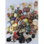 A collection of ceramic, cloisonné, stone, and painted wooden eggs,