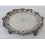 A HM silver salver raised over three ball and claw feet, featuring heraldic device upon, 22cm wide,