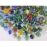 A collection of ninety vintage cats eye glass marbles.