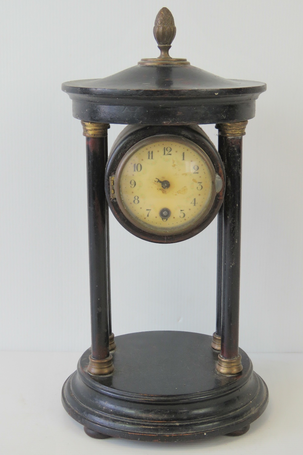 A 30hr clock contained within an Architectural pedimental four column base.