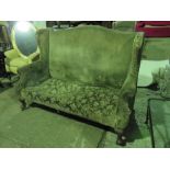 A 19th century high wing back two seater settee raised over substantial short legs,