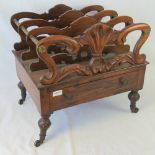 A four sectional Canterbury in rosewood, having single frieze drawer and raised over brass wheels,