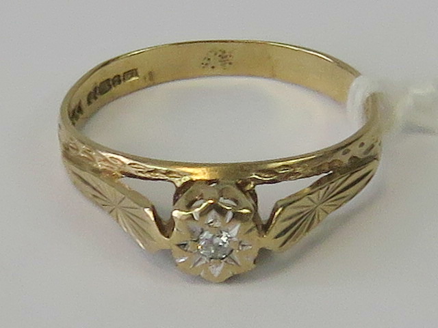 A 9ct gold and diamond ring, illusion set brilliant cut diamond in raised gallery, hallmarked 375,