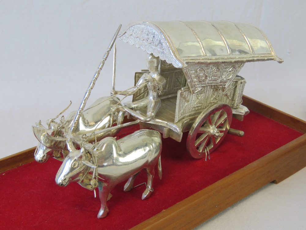 A white metal bullock cart with driver, stamped 800, upon wooden stand with glass cover, - Image 2 of 2