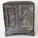 A delightful embossed metal cabinet having two doors with mythological figures upon,