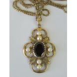 A 9ct gold pearl and garnet pendant having large central oval cut garnet with pearls set floral