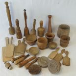 A collection of vintage treen kitchenalia including butter pats and moulds, pestles and mortars,