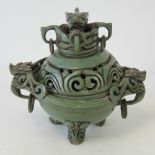 An ornate 19th century Chinese ceramic lidded censer of bowl form raised over three incised legs,