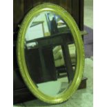 A contemporary bevel edged oval gilt framed wall mirror.