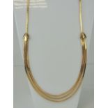 An 18ct gold articulated necklace having central trio of graduated snake link chain with triform