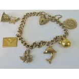 A gilded HM silver curb link charm bracelet having two attached 9ct gold charms,