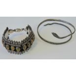 A white metal and niello upper arm bangle in the form of a coiled snake,