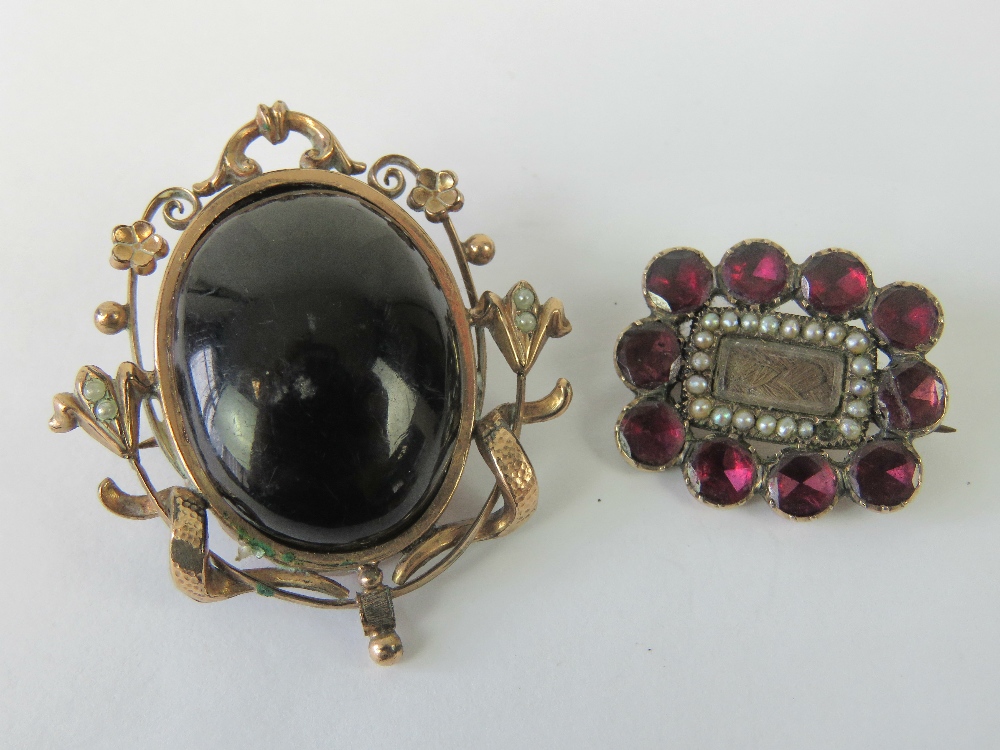 A delightful Edwardian rose metal brooch having central black cabachon,