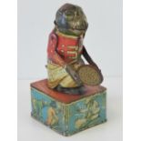 A rare tin plate monkey money box with moving arms and mouth,