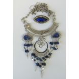 A vintage white metal brooch having central marquise blue cabachon surrounded by white stones,